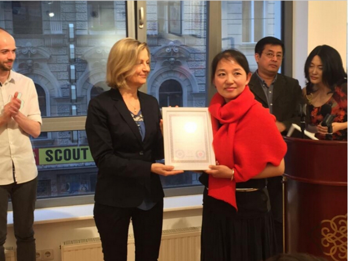 奥地利联邦总理府新闻官艾琳·考夫曼女士给闫慧颁发参展证书