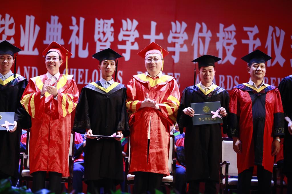 校领导穆瑞杰、李明中为首届本科毕业生代表拨苏正冠、颁发学位证书