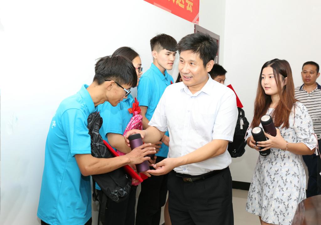 李明中、曾照烨为志愿者发放纪念品