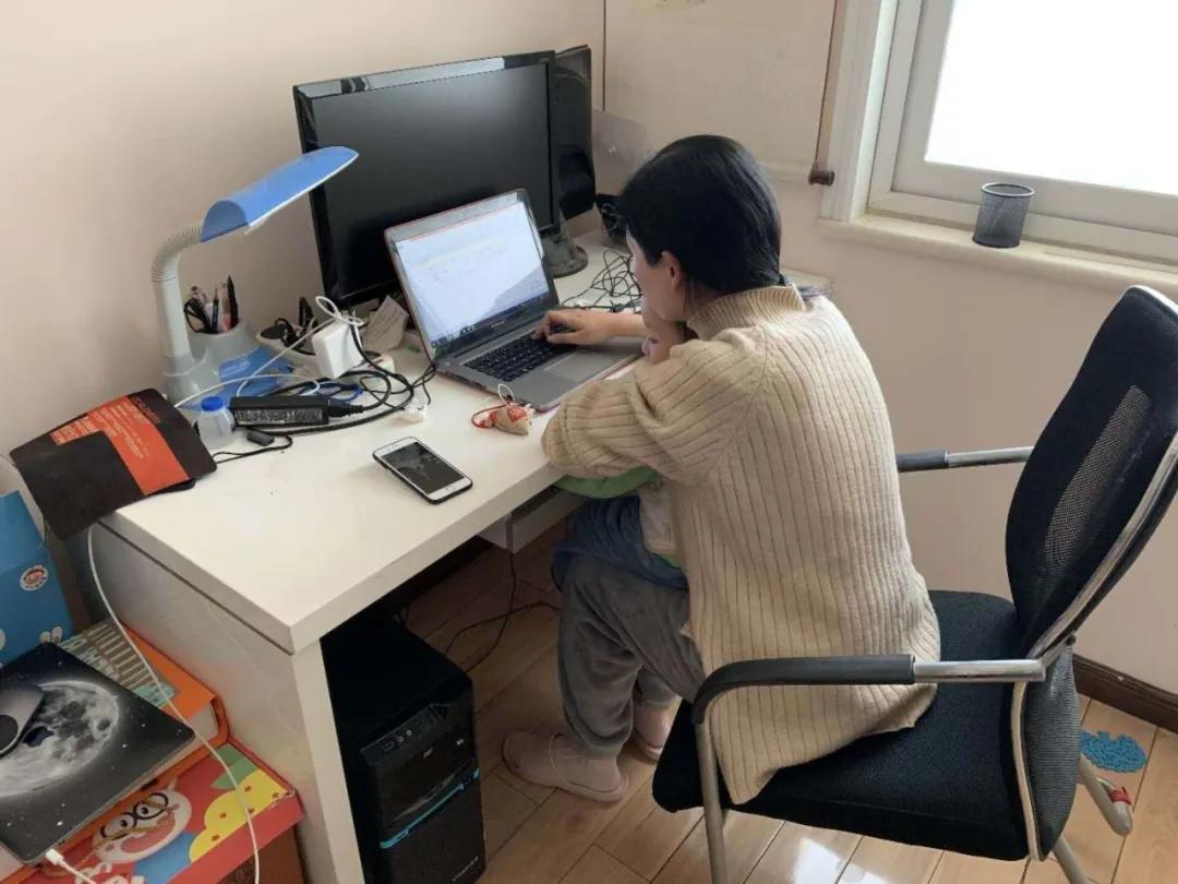 辅导员段婧边安抚孩子边进行学习疫情信息统计